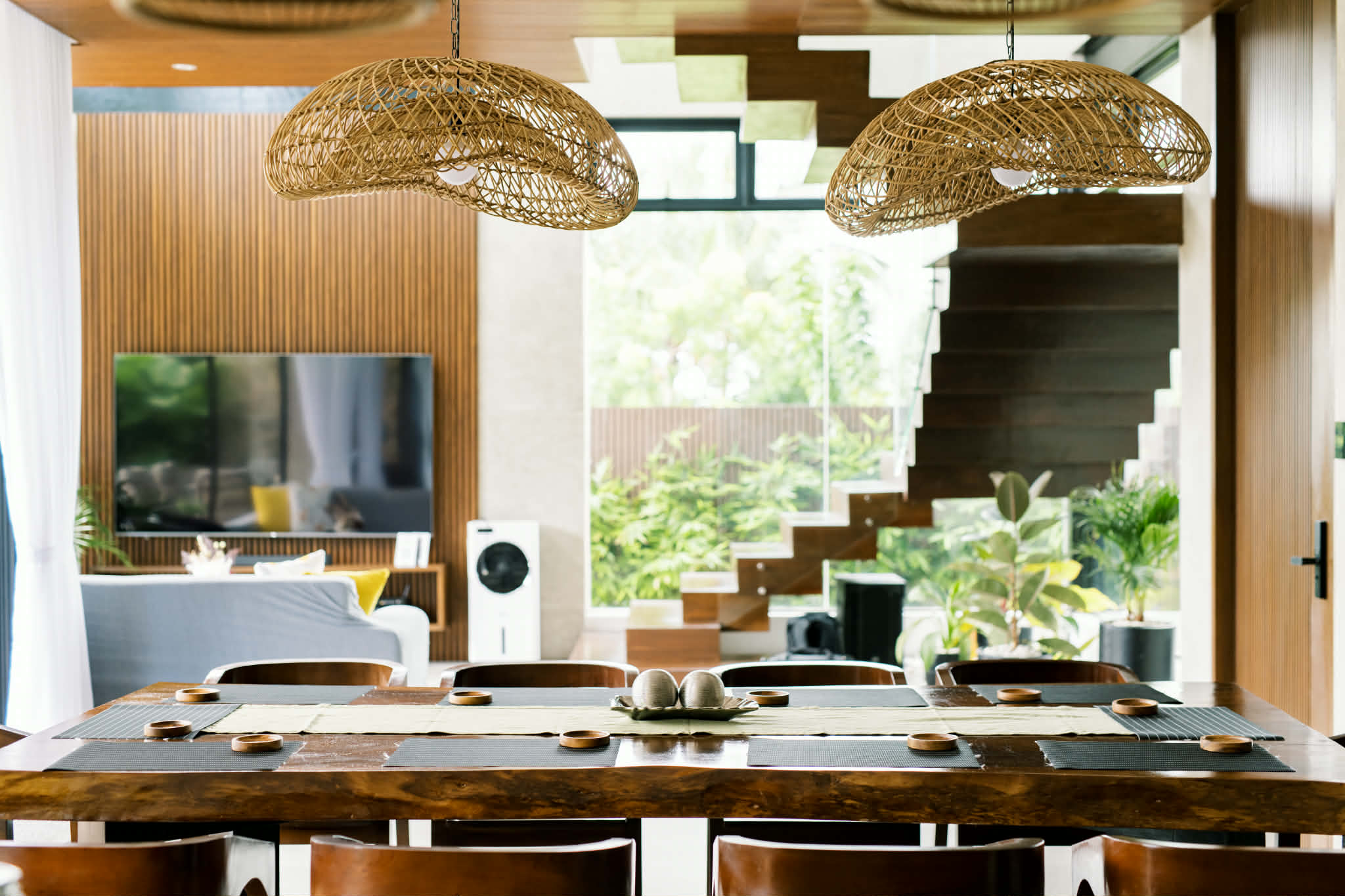 Dining table looking onto the lounge, floating staircase, and garden windows