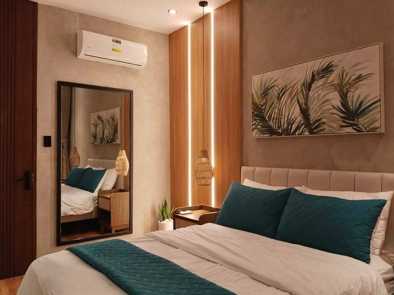 Room 1 — queen bedroom with warm wood panelling and rattan pendant light